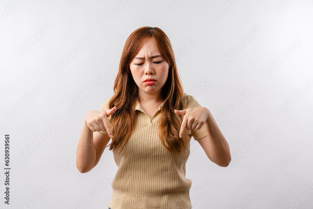 Portrait of displeased offended young Asian woman looks angrily aside doesnt agree with somebodys opinion wears cream clothes isolated over white background Portrait of displeased offended young Asian woman looks angrily aside doesnt agree with somebodys opinion wears cream clothes isolated over white background