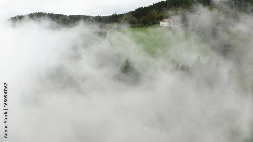 Aerial view revealing a road in middle of foggy meadows and forest in Tyrol, Italy Aerial view revealing a road in middle of foggy meadows and forest in Tyrol, Italy