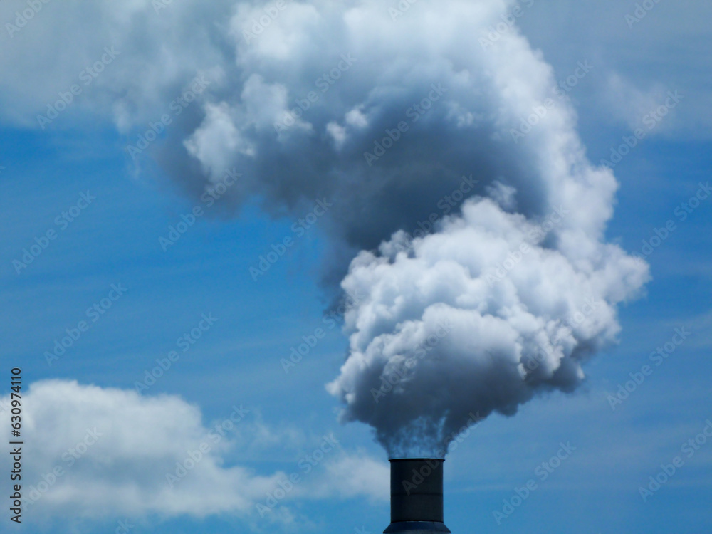 white smoke spewed into the air. blue sky. low angle closeup view. chimney, industrial smoke stack detail. environment and air pollution concept. blue sky and white clouds. abstract image. white smoke spewed into the air. blue sky. low angle closeup view. chimney, industrial smoke stack detail. environment and air pollution concept. blue sky and white clouds. abstract image.