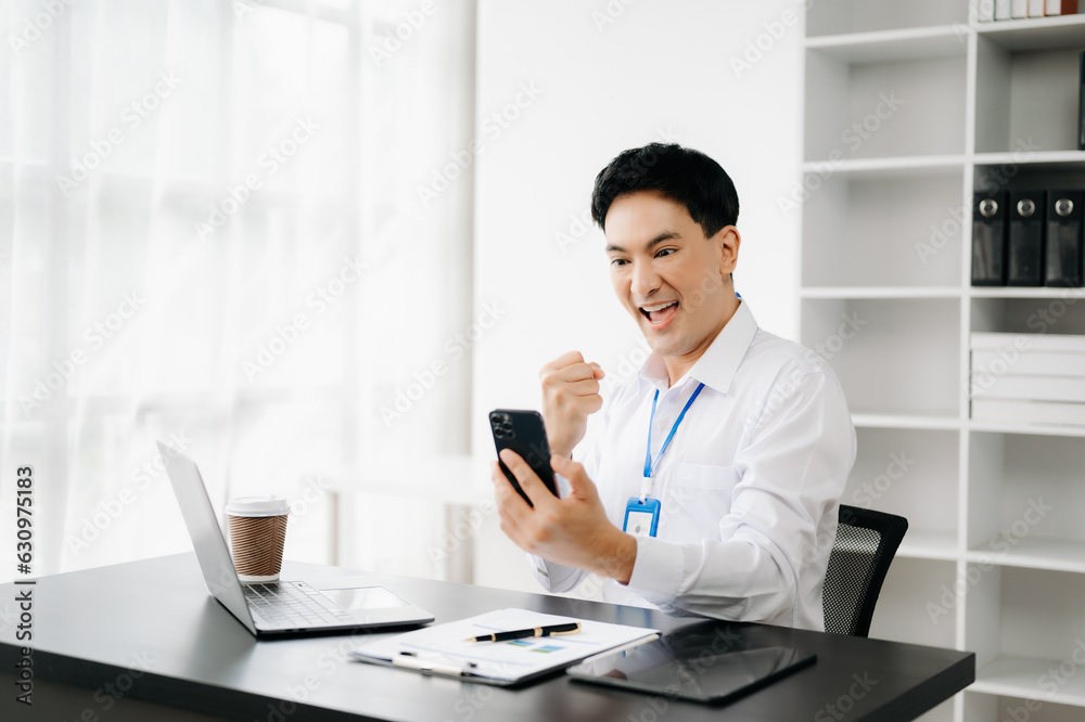 Asian business man are delighted and happy with the work they do on their tablet, laptop and taking notes at the office.. Asian business man are delighted and happy with the work they do on their tablet, laptop and taking notes at the office..