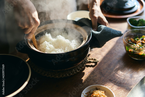 土鍋で炊いたご飯をしゃもじで混ぜる photo