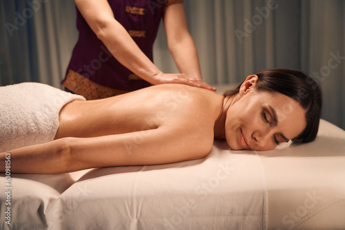 Female client getting upper back massage in wellness center