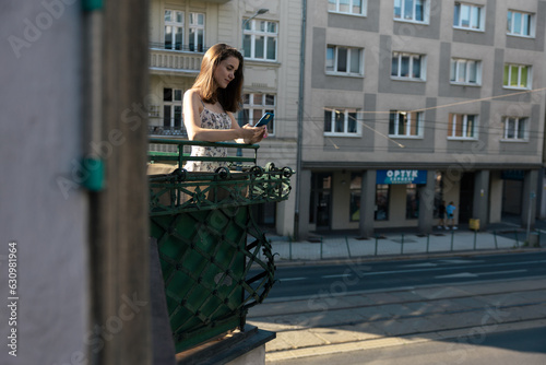 A girl in a dress takes a selfie on the background of the city