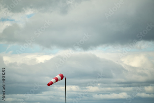 Windsock against sky with heavy clouds