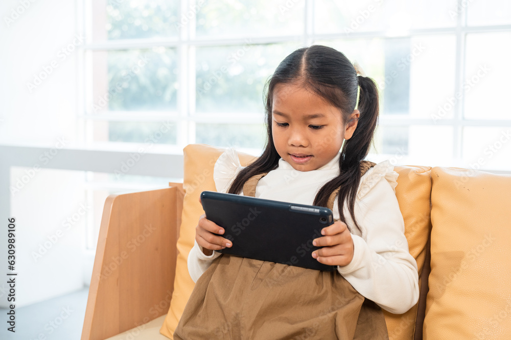 Little girl with tablet looking cartoon. Daughter using digital tablet for education online homework Little girl with tablet looking cartoon. Daughter using digital tablet for education online homework