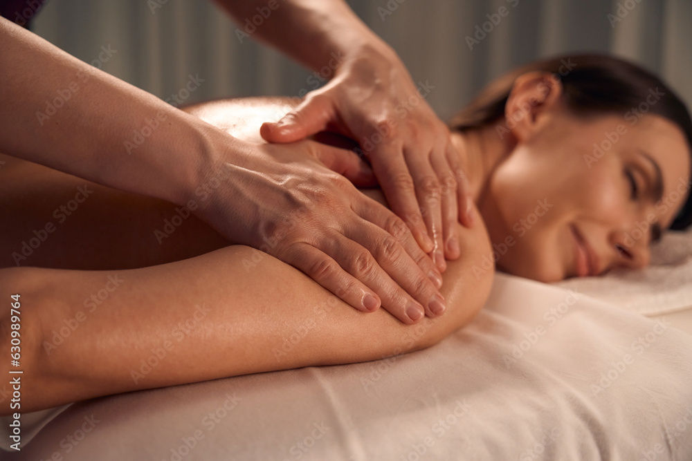 Spa patient sleeping during upper arm massage session Spa patient sleeping during upper arm massage session