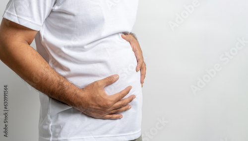 Man touching his fat belly on white background. Paunch of a man. Overweight photo