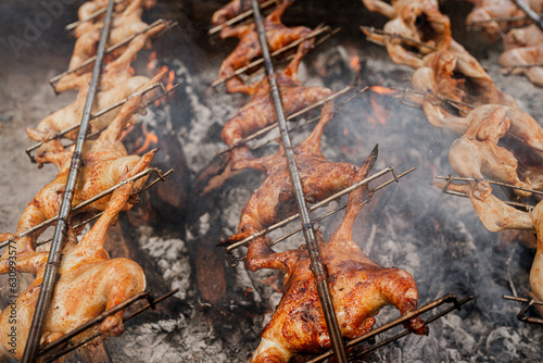 Huli-huli chicken is a grilled chicken dish in Hawaiian cuisine, prepared by barbecuing a chicken over mesquite wood, Prosopis pallida , kiawe photo