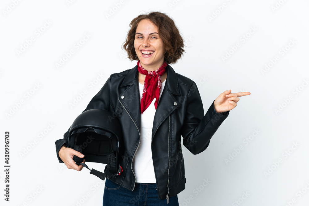 English woman holding a motorcycle helmet isolated on white background pointing finger to the side English woman holding a motorcycle helmet isolated on white background pointing finger to the side