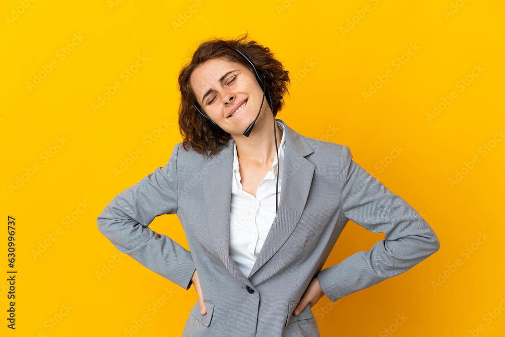 Young English woman isolated on yellow background suffering from backache for having made an effort