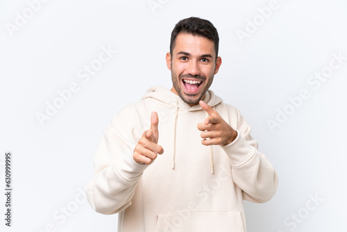 Young caucasian man isolated on white background pointing to the front and smiling