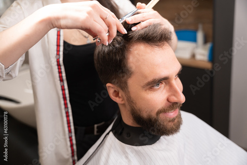 Smiling man sits in a barber chair