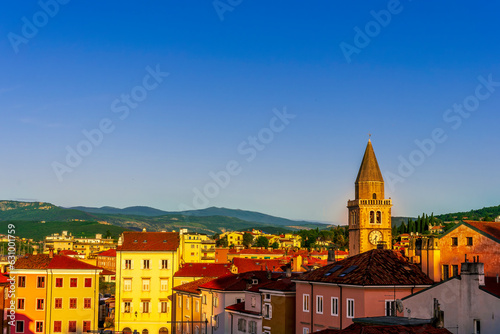 Stampa su tela amazing evening town with church, tower with bell , yellow houses and beautiful