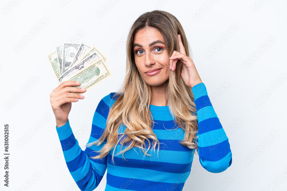 Young Uruguayan woman taking a lot of money isolated on white background thinking an idea Young Uruguayan woman taking a lot of money isolated on white background thinking an idea