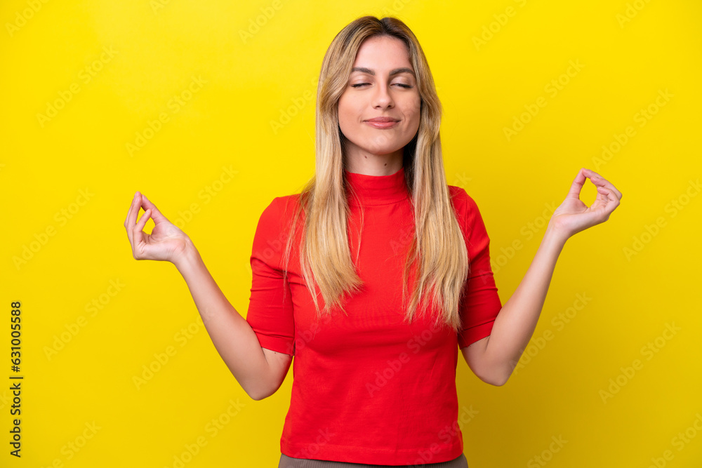 Young Uruguayan woman isolated on yellow background in zen pose Young Uruguayan woman isolated on yellow background in zen pose