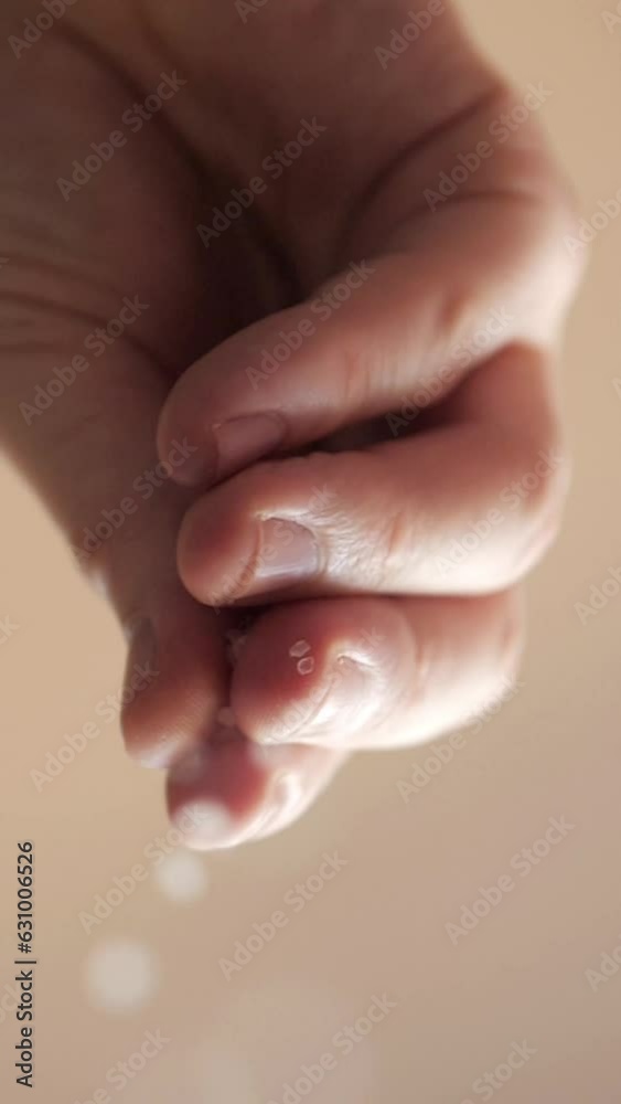 sprinkling salt. A hand sprinkling salt down onto the camera lens. vertical video sprinkling salt. A hand sprinkling salt down onto the camera lens. vertical video