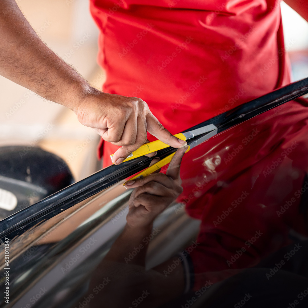 Car side window film removal and tinting installation. Male auto