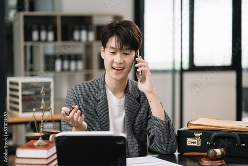 Male Legal counsel discussing involved in cellphone call conversation consultation to client contract papers sitting in the table at office in the morning. concepts of law, advice, legal services.