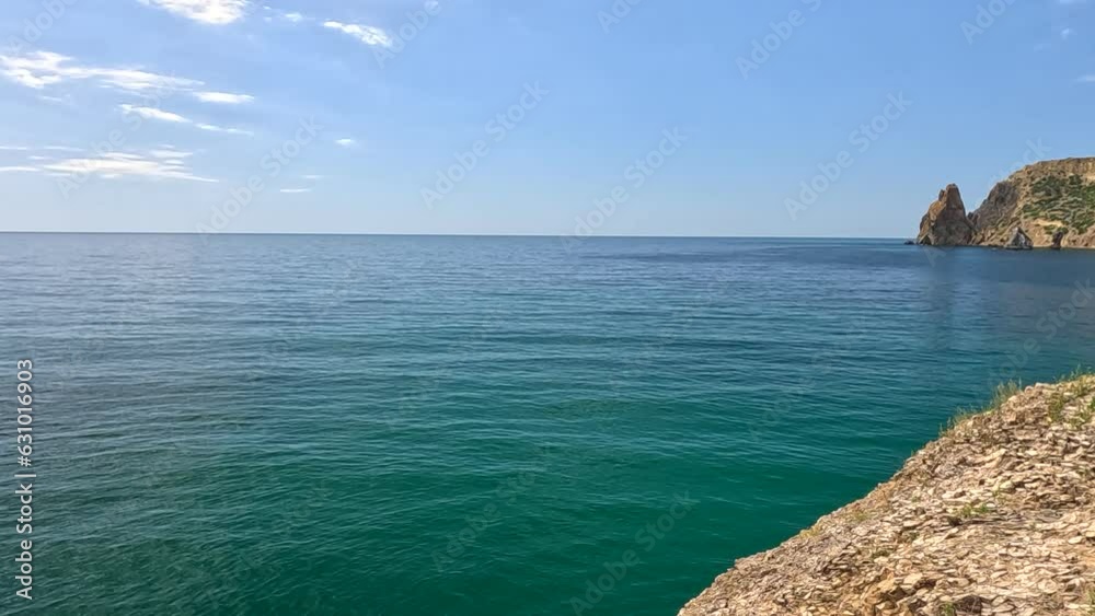 Sea water surface. Aerial view on calm azure sea and volcanic rocky shores. Small waves on water surface in motion blur. Nature summer ocean sea beach background. Nobody. Weather and climate change Sea water surface. Aerial view on calm azure sea and volcanic rocky shores. Small waves on water surface in motion blur. Nature summer ocean sea beach background. Nobody. Weather and climate change