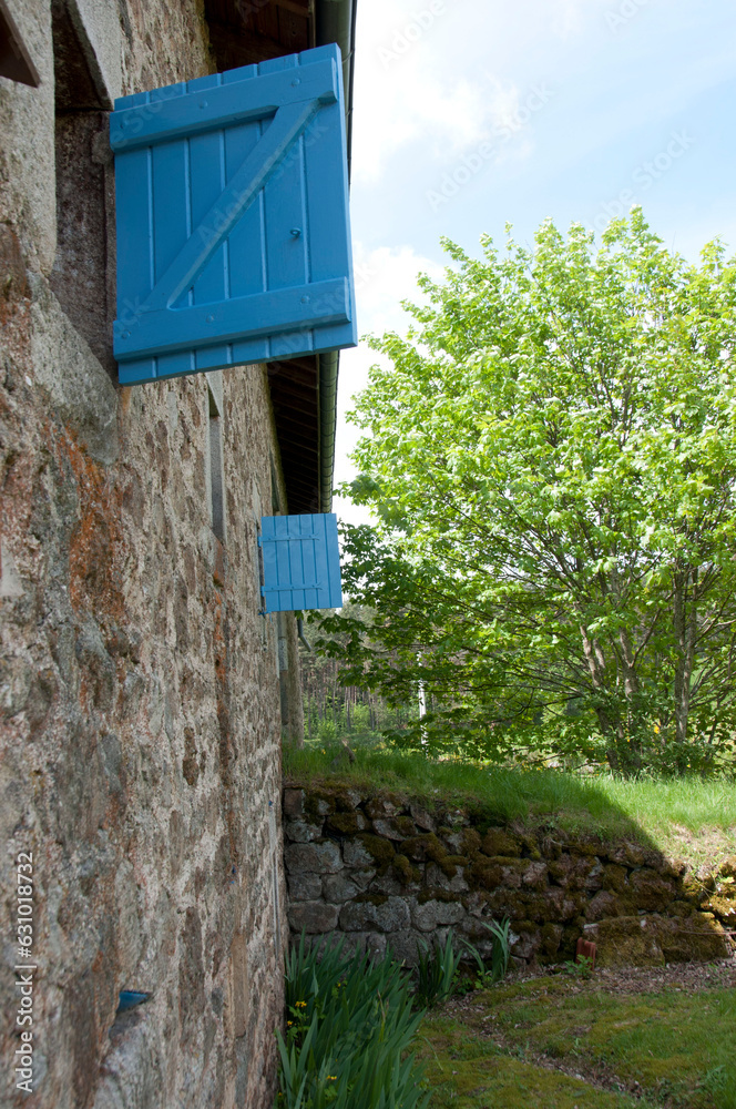 Blue shutters on French rural house in Auvergne region of France