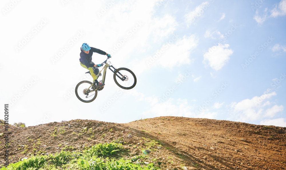 Fototapeta premium Mountain bike, man and jump in sky for competition, freedom and off road adventure. Athlete, extreme sports and bicycle in air for action, cardio race and stunt power in nature, path and mockup space