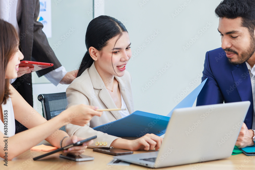 Asian Indian multinational professional successful bearded male businessman explaining discussing brainstorming with female businesswomen colleagues in formal business suit in office meeting room