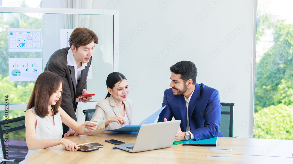 Asian Indian multinational professional successful bearded male businessman explaining discussing brainstorming with female businesswomen colleagues in formal business suit in office meeting room