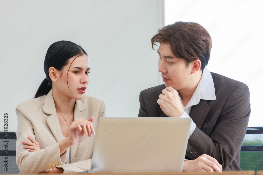 Asian professional successful male businessman explaining discussing brainstorming with female businesswoman colleague in formal business suit via laptop notebook computer in office company workplace Asian professional successful male businessman explaining discussing brainstorming with female businesswoman colleague in formal business suit via laptop notebook computer in office company workplace