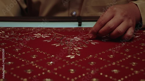 handcrafting traditional red headscarf shawl keringkam using embroidery with gold threads intricately photo