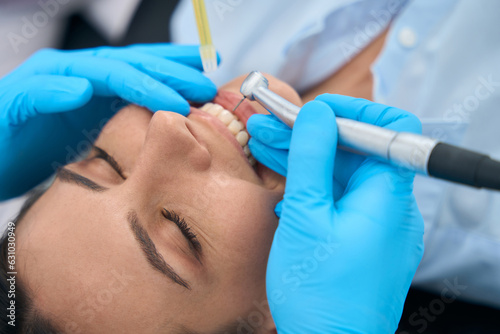 Fotografie, Obraz Close-up nurse holding saliva ejector while dentist holding drill