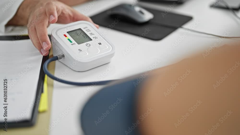 Young latin man doctor with patient measuring pulse using tensiometer at clinic Young latin man doctor with patient measuring pulse using tensiometer at clinic