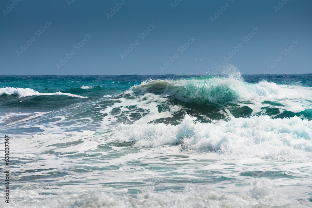 Waves on the beach in windy day. Blue sea and the blue sky.
