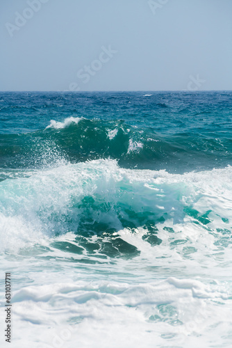 Waves on the beach in windy day. Santorini island, Greece. Blue sea and the blue sky.