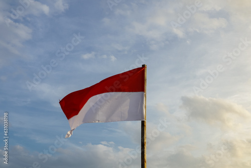 Indonesian national flag flying in the afternoon with blue sky and bright clouds