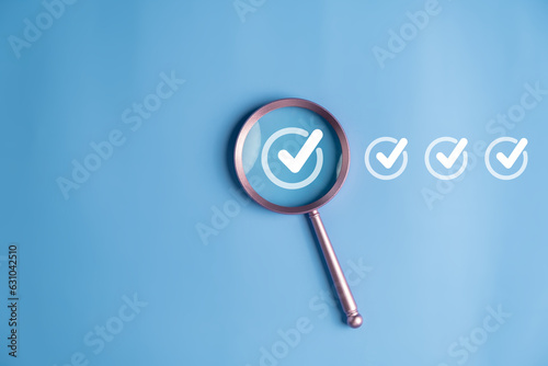 Magnifier enlarging the correct or check mark on blue background. photo