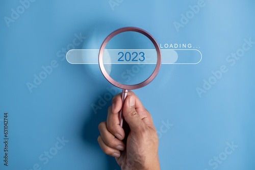 Loading to next year 2023 concept. Words 2023 plans on magnifying glass.