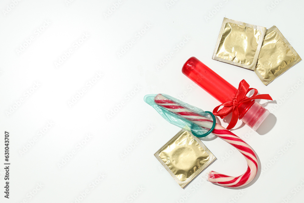 Lubricant in a red bottle with a bow, condoms and candy, place for text Lubricant in a red bottle with a bow, condoms and candy, place for text