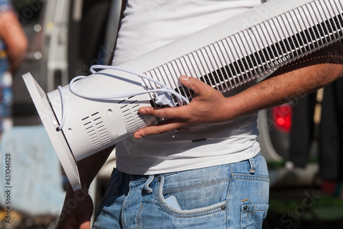 Main d'homme portant un appareil de climatisation acheté dans une brocante photo