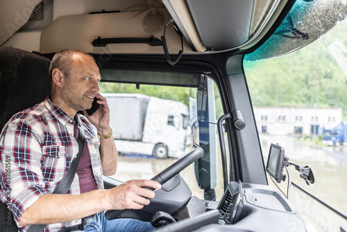 Experienced truck driver calls to a customer with a delivery done and the truck parked at the industrial parking lot