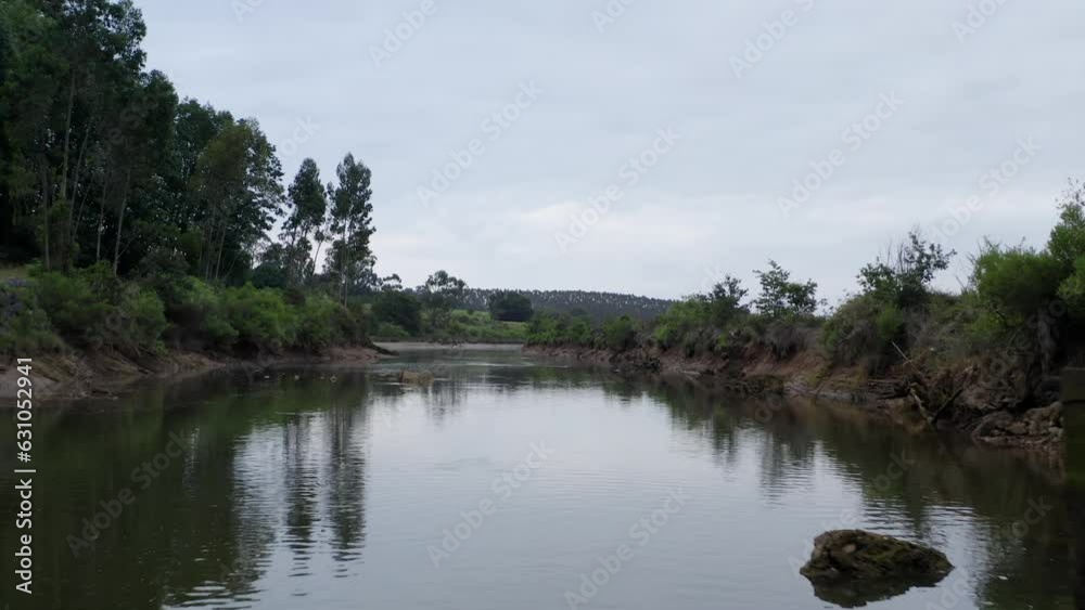 Peaceful pov view as boat move below bridge on tranquil river. Cantabria, Spain Peaceful pov view as boat move below bridge on tranquil river. Cantabria, Spain