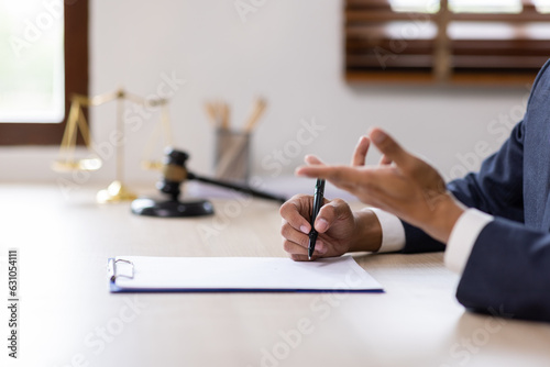 Fotografie Statue of Justice and male lawyer in suit at workplace with laptop, gavel and femida in office