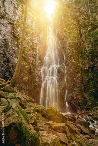 Burgbach Waterfall in coniferous forest falls over granite rocks into the valley near Bad Rippoldsau-Schapbach, Black Forest, Germany. Amazing beautiful natural waterfall called burgbachwasserfall of photo