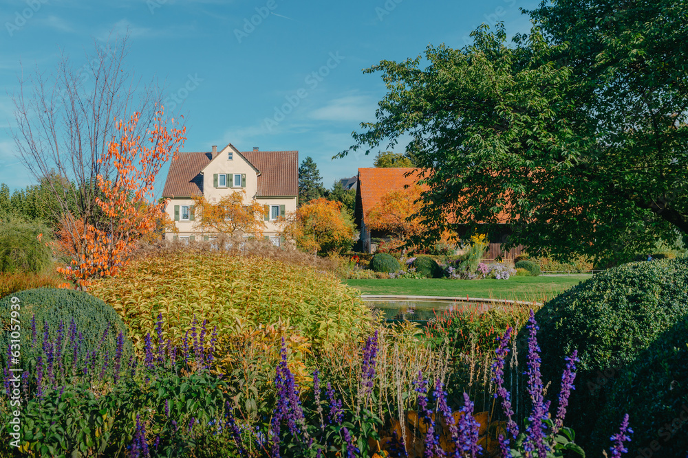 House with nice garden in fall. Flowers in the City Park of Bietigheim-Bissingen, Baden-Wuerttemberg, Germany, Europe. Autumn Park and house, nobody, bush and grenery House with nice garden in fall. Flowers in the City Park of Bietigheim-Bissingen, Baden-Wuerttemberg, Germany, Europe. Autumn Park and house, nobody, bush and grenery