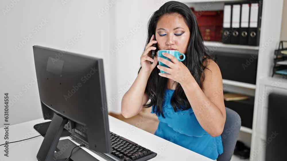 Young chinese woman business worker talking on smartphone drinking coffee at the office Young chinese woman business worker talking on smartphone drinking coffee at the office