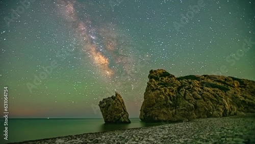 Time lapse at night of starry sky in Cyprus aphrodites rock viewpoint with shooting stars and ocean view photo
