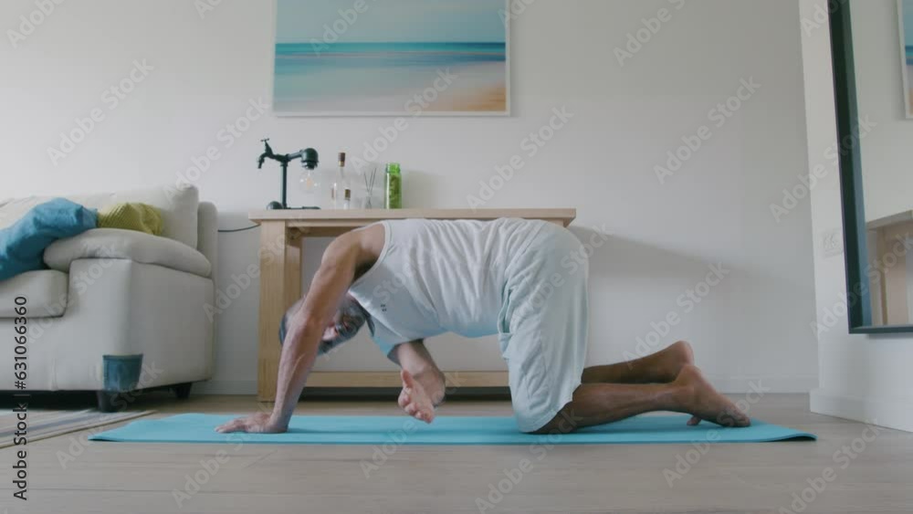 40 year old Middle Eastern man does morning yoga at home before the kids wake up 40 year old Middle Eastern man does morning yoga at home before the kids wake up