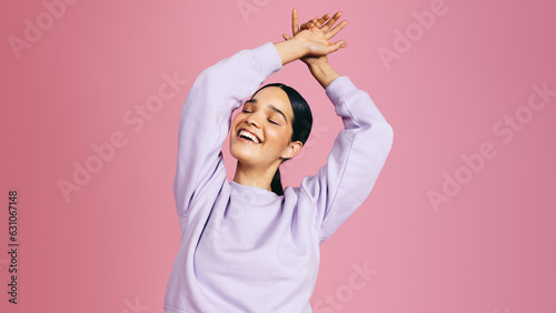 Happy gen z female dancing and celebrating herself in casual clothing