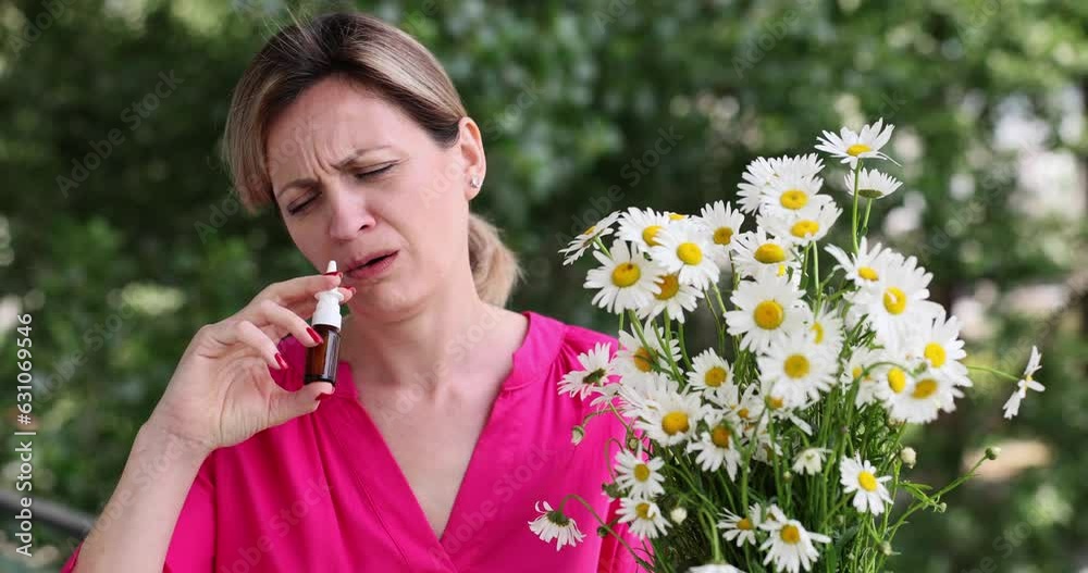 Woman sniffs chamomile after spraying nose for allergy to flowers. Concept of illness and discomfort. Spring flowering in warm season slow motion Woman sniffs chamomile after spraying nose for allergy to flowers. Concept of illness and discomfort. Spring flowering in warm season slow motion