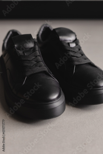 Close up details of black sneakers on the floor. Casual fashion style minimalistic shoes. © zvkate