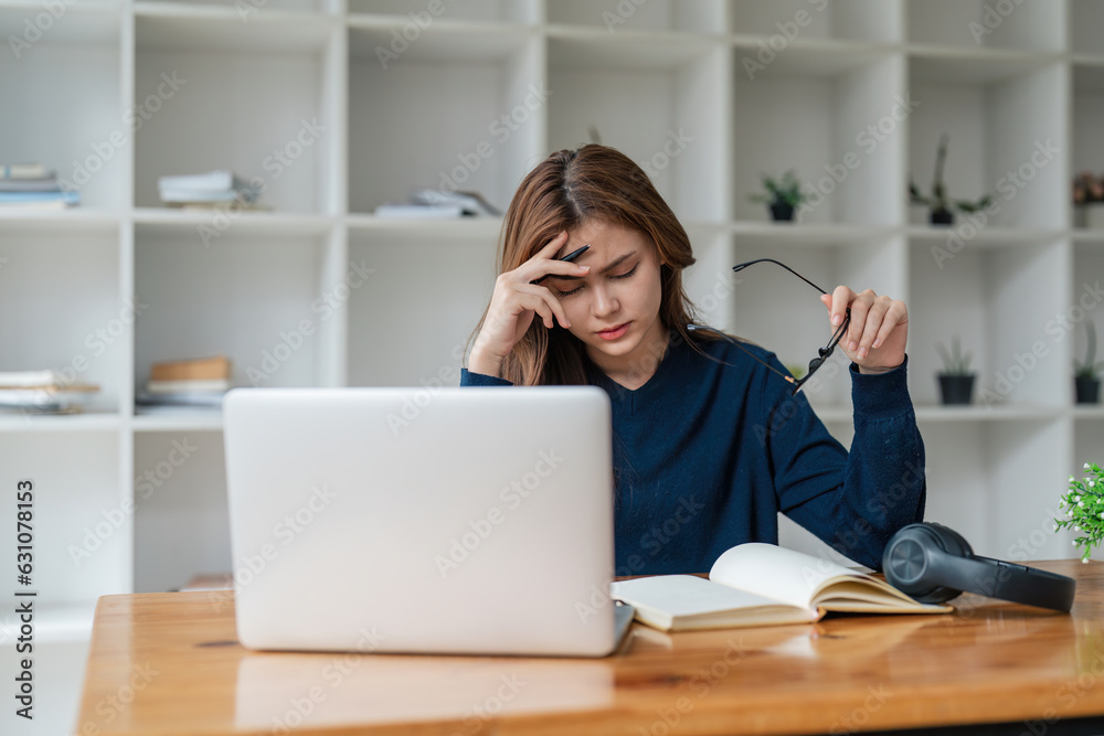 Tired asian woman bored with of laptop sad and frustrated about distance learning or online education sits at desk at home